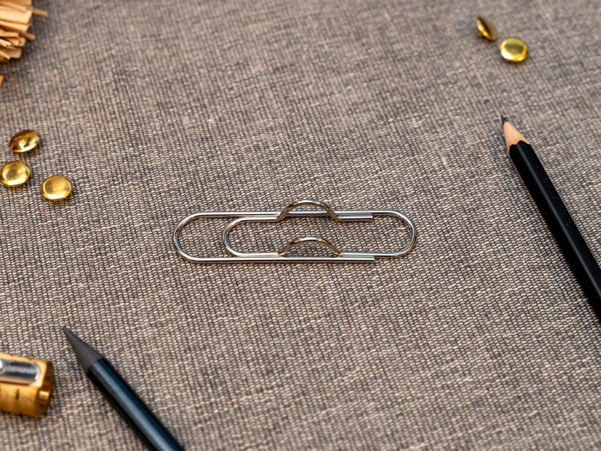 Silver notebook pen clip in that looks like a paperclip