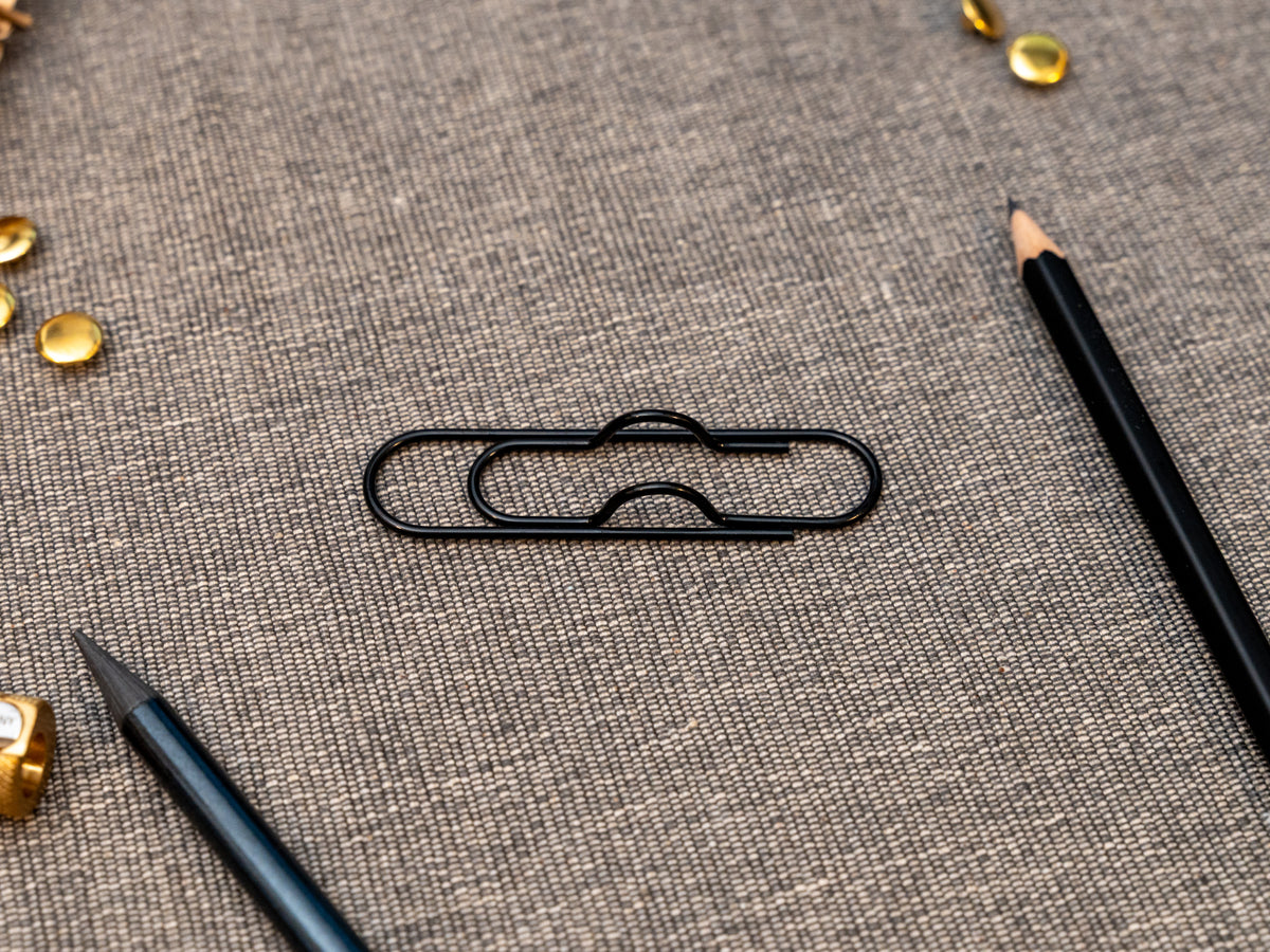 Black notebook pen clip in that looks like a paperclip