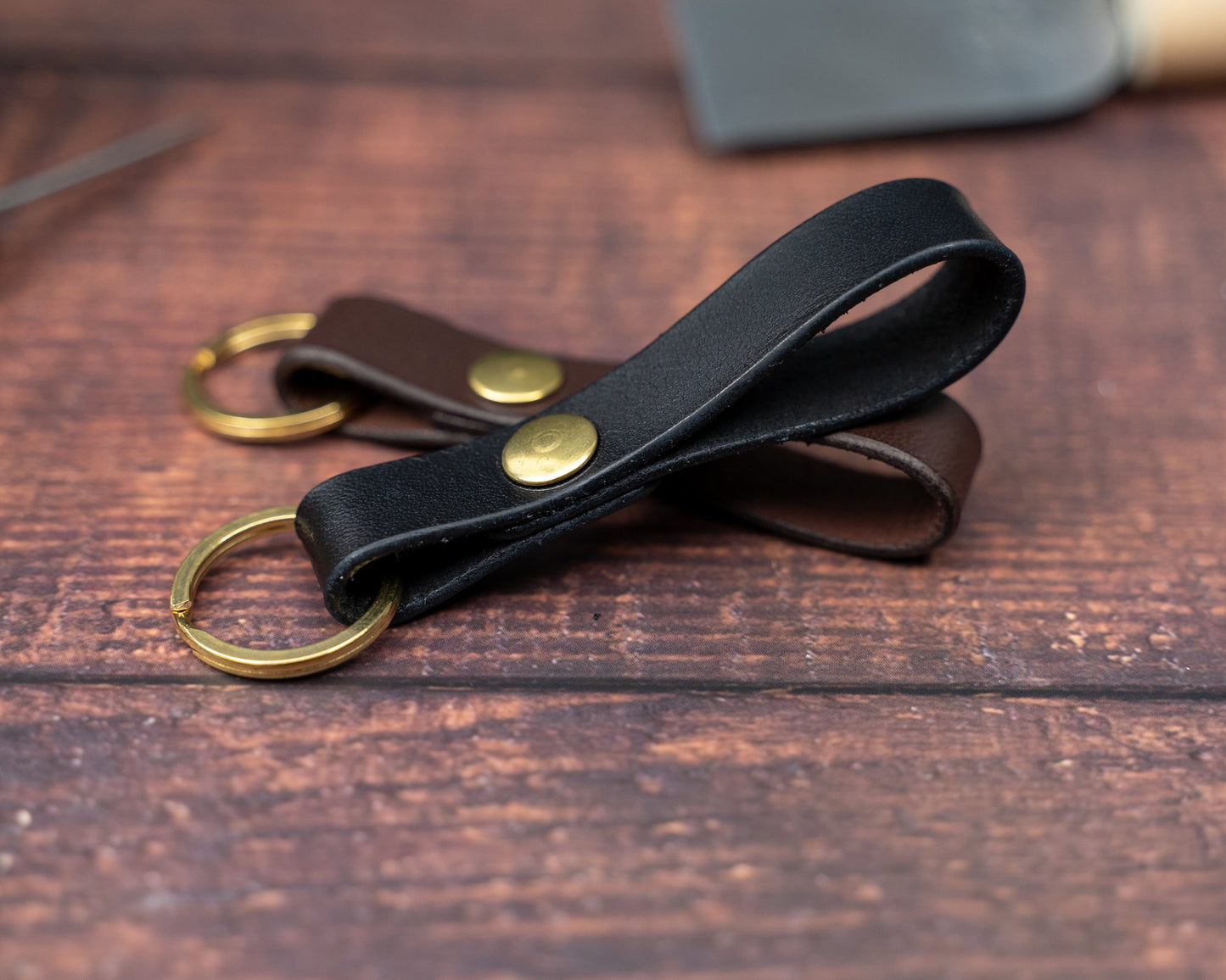 Black leather loop keyring over a dark brown leather loop keyring