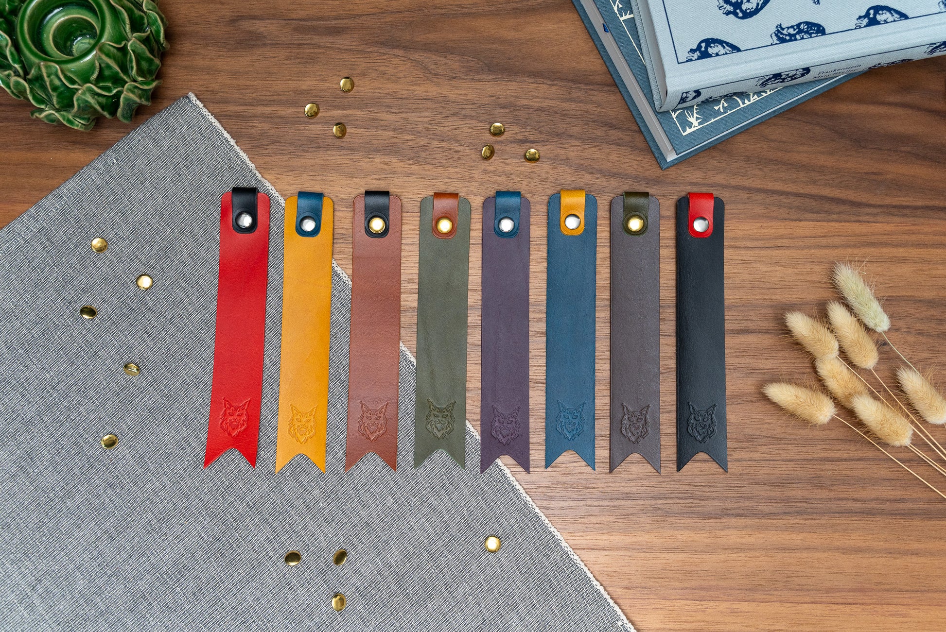 Leather bookmark in a selection of colours with folded tab over the top and a cut out at the bottom. Bookmark is debossed with an outline of a Maine Coon cats face. Stainless steel and brass rivets used to hold tab in place. Available in red, yellow, tan, olive green, purple, navy blue, dark brown, black with a choice of tab colour.