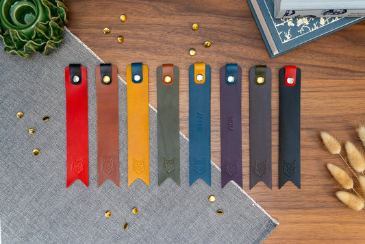 Leather bookmark in a selection of colours with folded tab over the top and a cut out at the bottom. Bookmark is debossed with an outline of a Maine Coon cats face. Stainless steel and brass rivets used to hold tab in place. Available in red, yellow, tan, olive green, purple, navy blue, dark brown, black with a choice of tab colour.