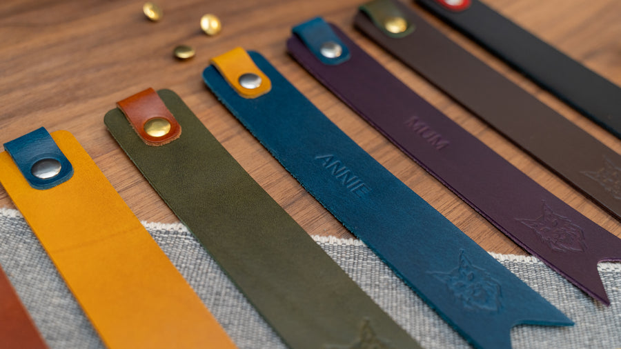 Leather bookmark in a selection of colours with folded tab over the top and a cut out at the bottom. Bookmark is debossed with an outline of a Maine Coon cats face. Stainless steel and brass rivets used to hold tab in place. Available in red, yellow, tan, olive green, purple, navy blue, dark brown, black with a choice of tab colour.