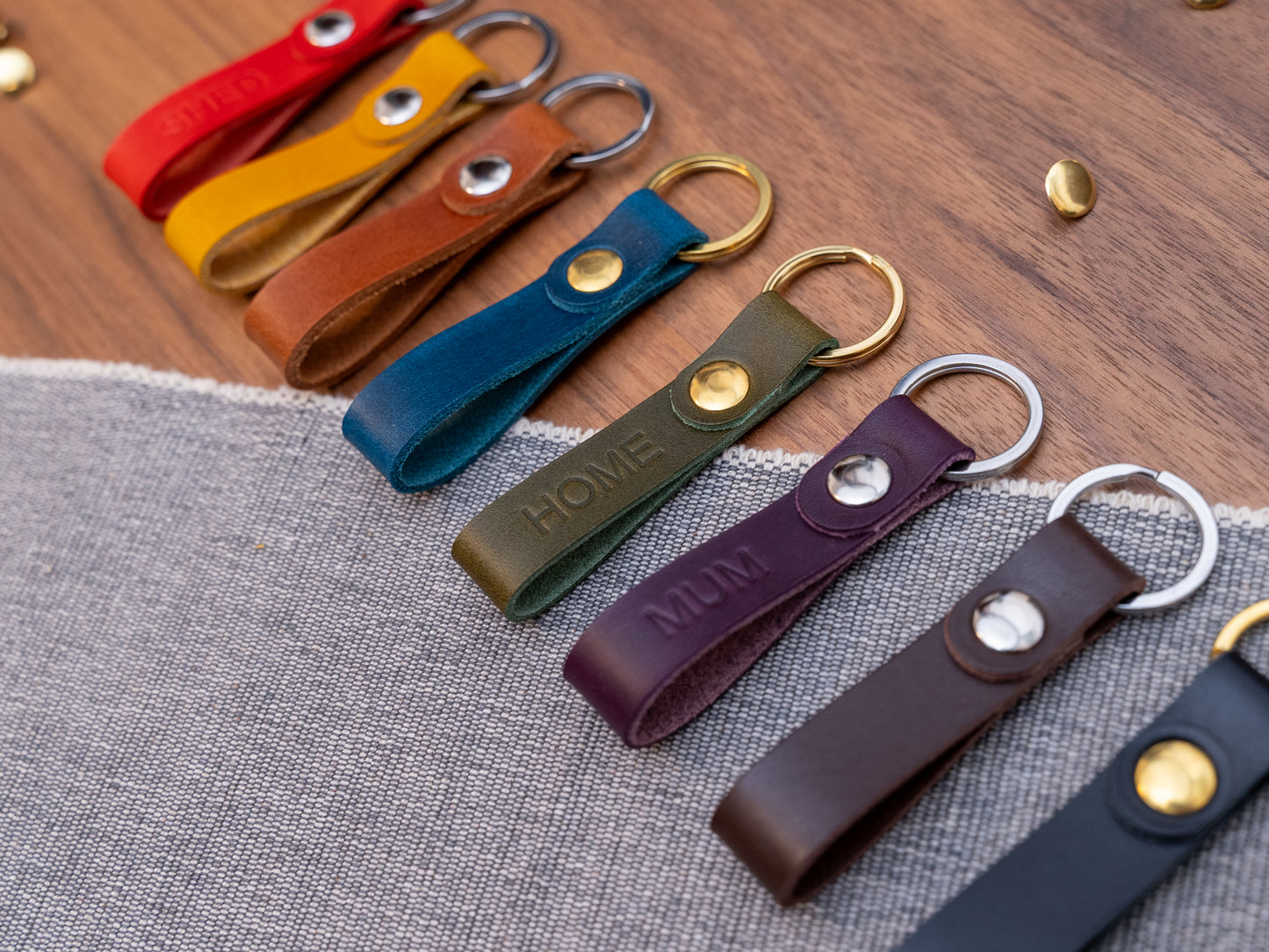 Slim Italian leather loop keyrings/keychains in multiple colours including black, brown, purple, olive green, navy blue, tan, yellow and red. Personalised with up to 6 letter debossed into the leather. Stainless steel or solid brass split ring and rivet.