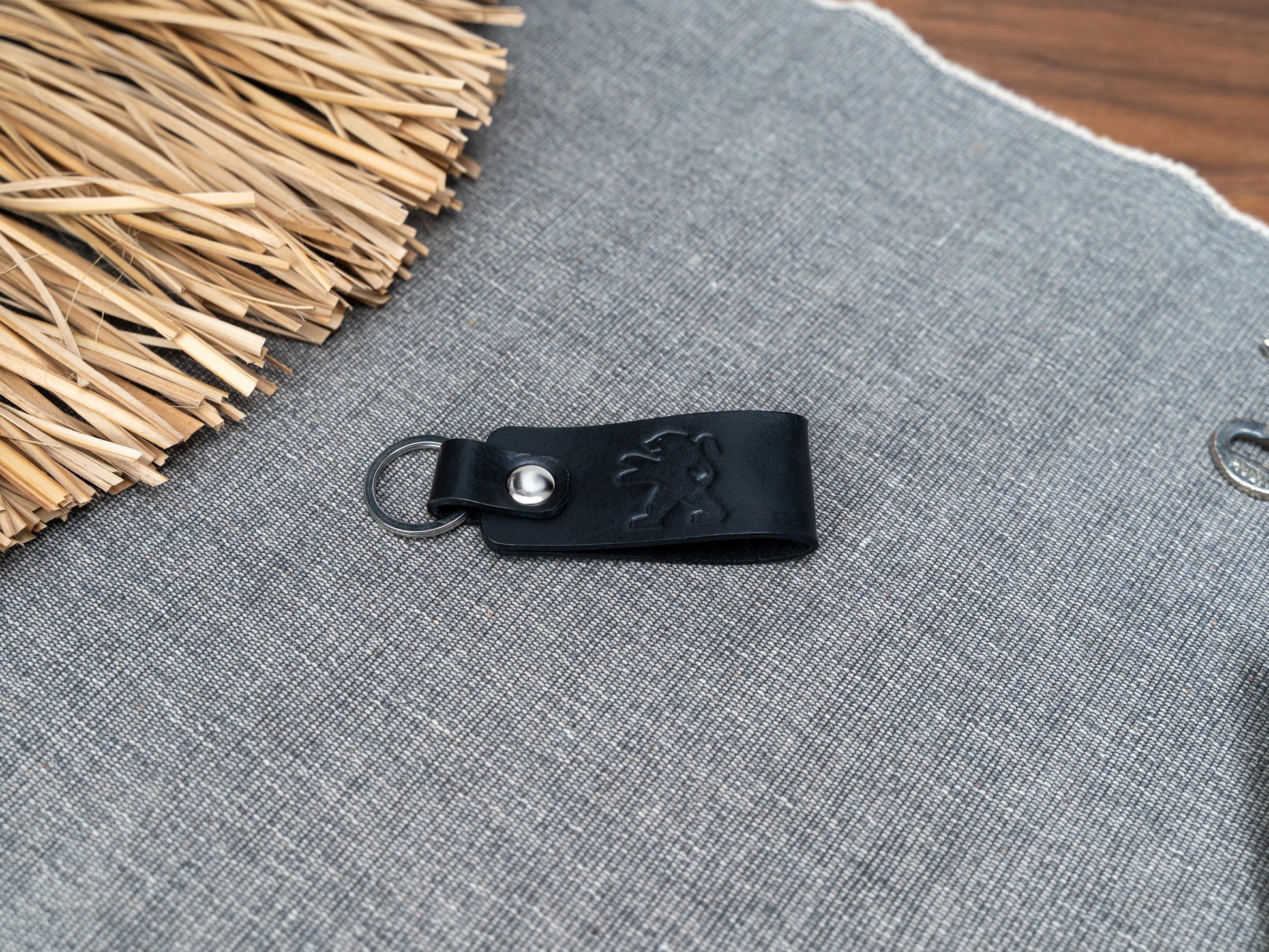 Folded black leather keyring with the Peugeot car logo debossed on it. Made from full grain leather.
