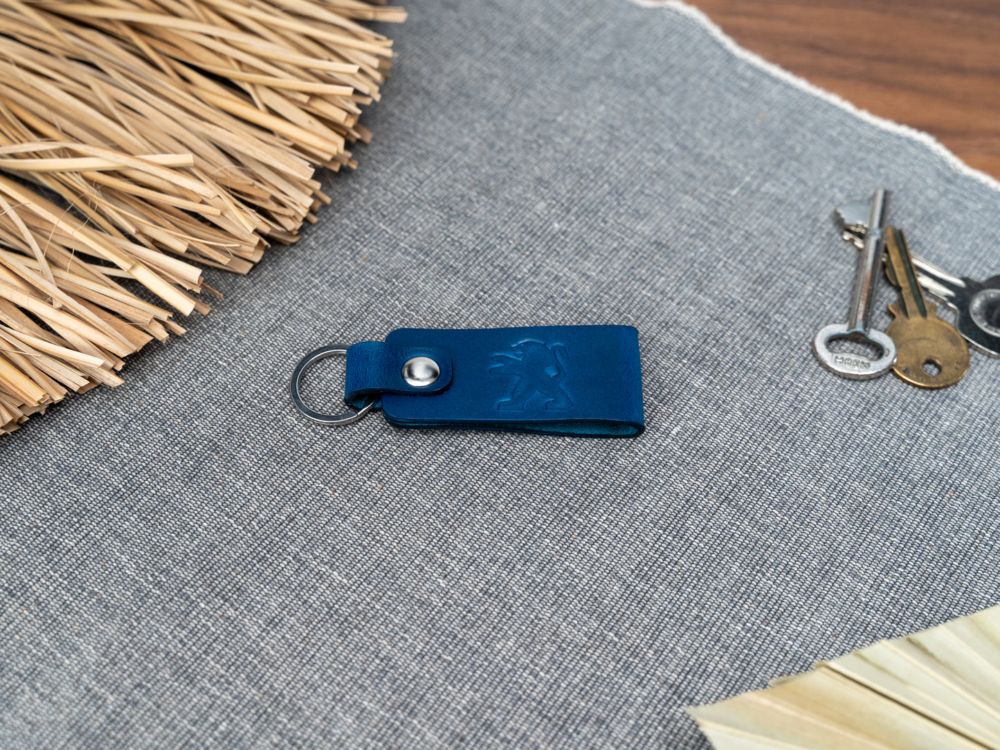 Folded navy blue leather keyring with the Peugeot car logo debossed on it. Made from Italian full grain leather