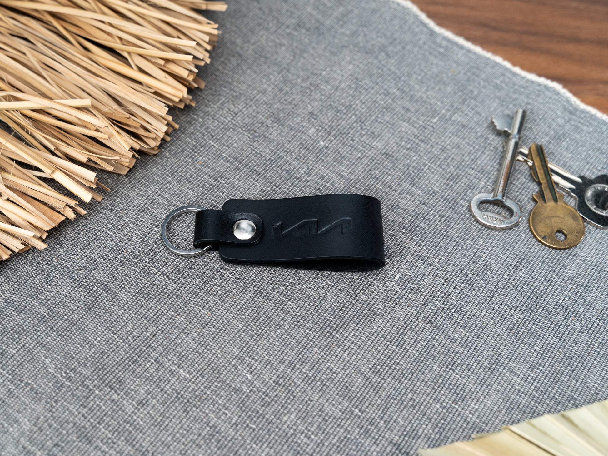 Folded black leather keyring with kia car logo debossed on it