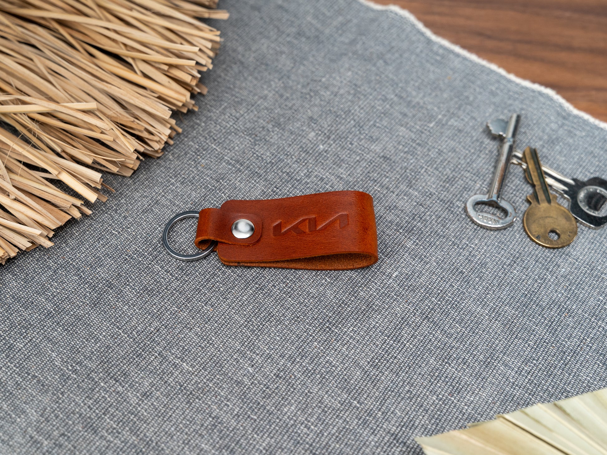 Folded tan leather keyring with kia car logo debossed on it
