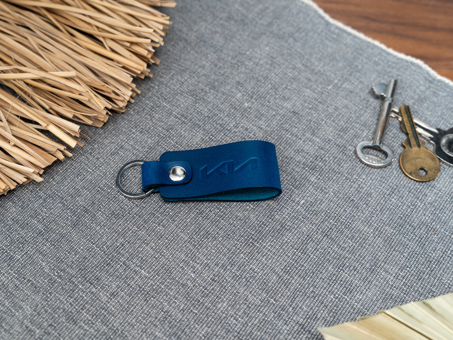 Folded navy blue leather keyring with kia car logo debossed on it