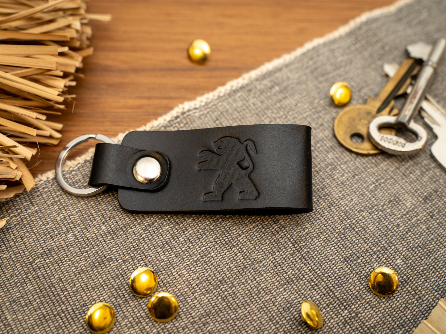 Folded black leather keyring/keychain with the Peugeot car logo debossed on it. Made from full grain leather.