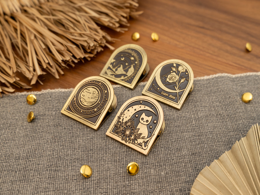 Vintage antique brass metal journal book clips in four designs - cat over a moon, planet solar system, rose, mountains