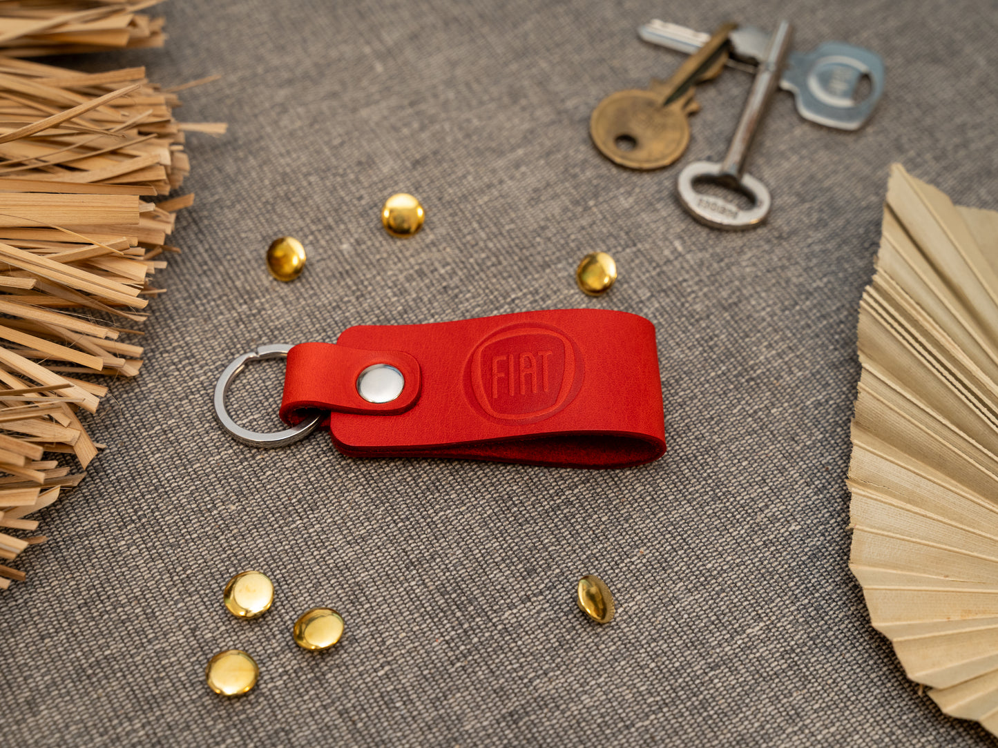 Keyring with a folded design in red. The keychain has been embossed with the Fiat car logo. Stainless steel split ring and rivet.