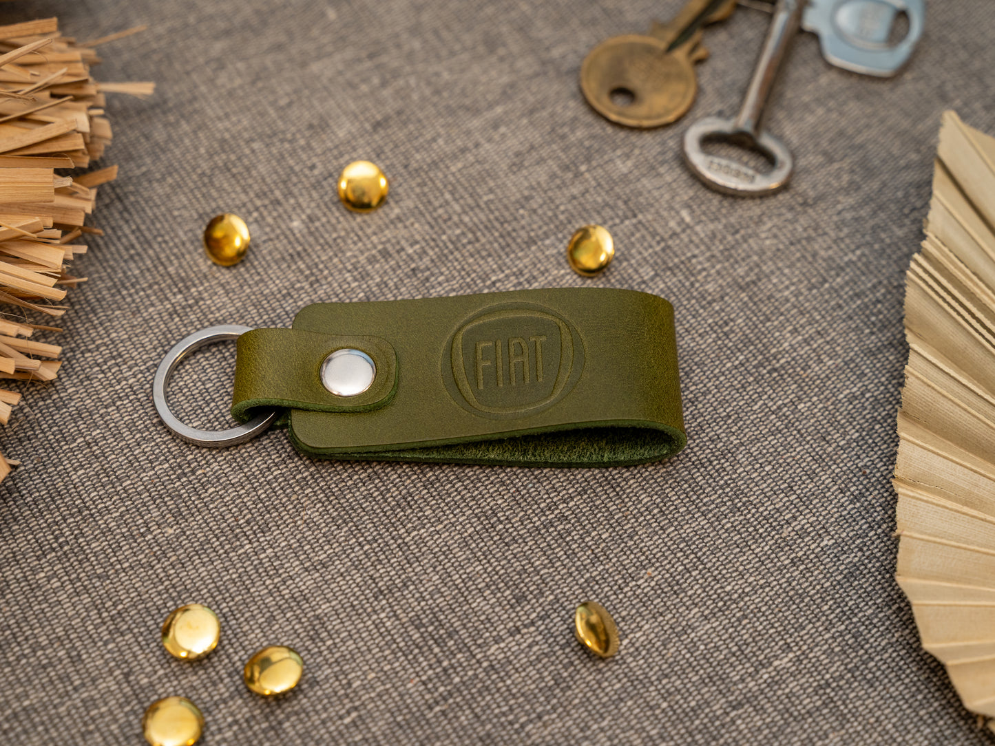 Keyring with a folded design in olive green. The keychain has been embossed with the Fiat car logo. Stainless steel split ring and rivet.