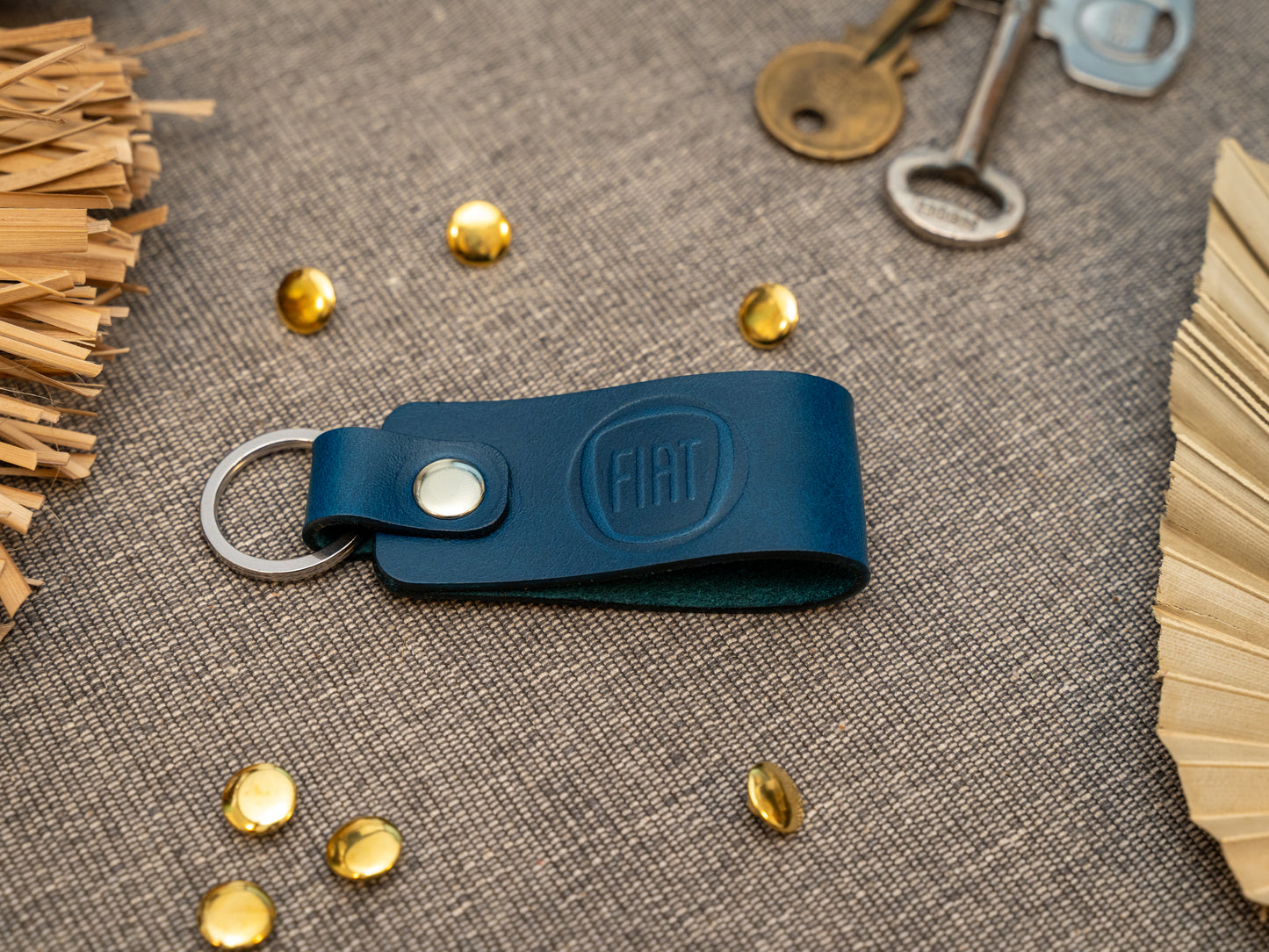 Keyring with a folded design in navy blue. The keychain has been embossed with the Fiat car logo. Stainless steel split ring and rivet.