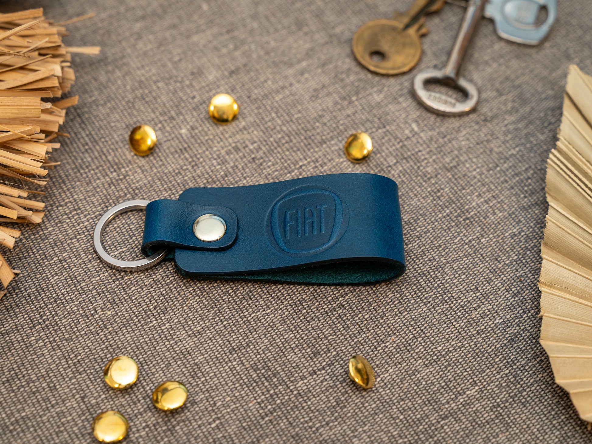 Keyring with a folded design in navy blue. The keychain has been embossed with the Fiat car logo. Stainless steel split ring and rivet.