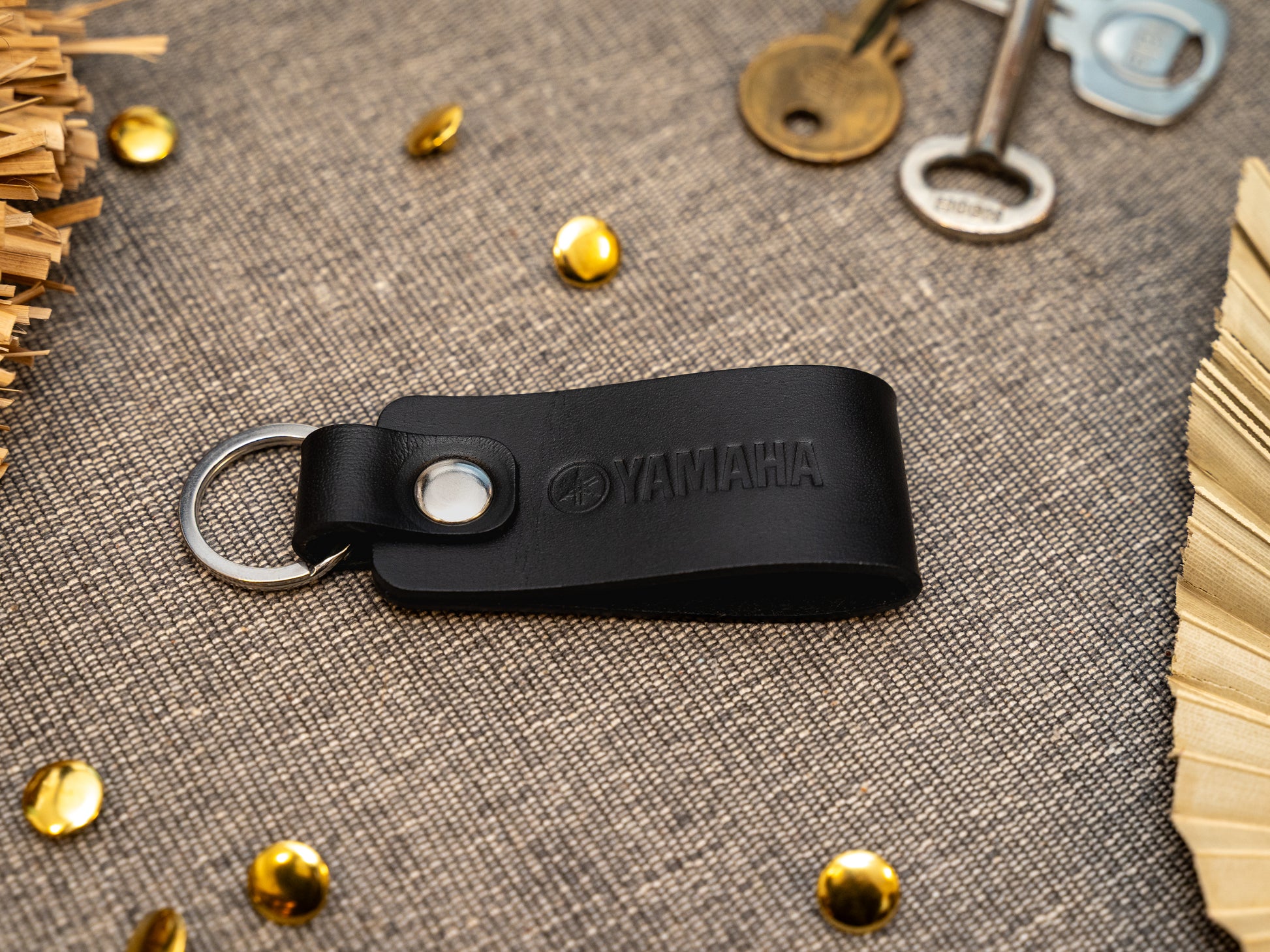 Keyring with a folded design in black. The keychain has been embossed with the Yamaha motorbike logo. Stainless steel split ring and rivet.
