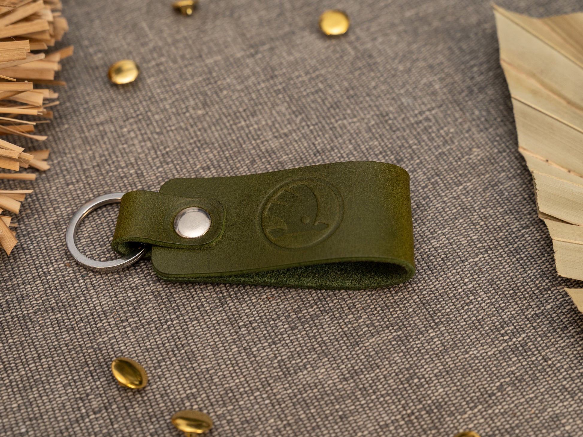 Keyring/keychain with a folded design in olive green. The keychain has been embossed with the Skoda car logo. Stainless steel split ring and rivet.