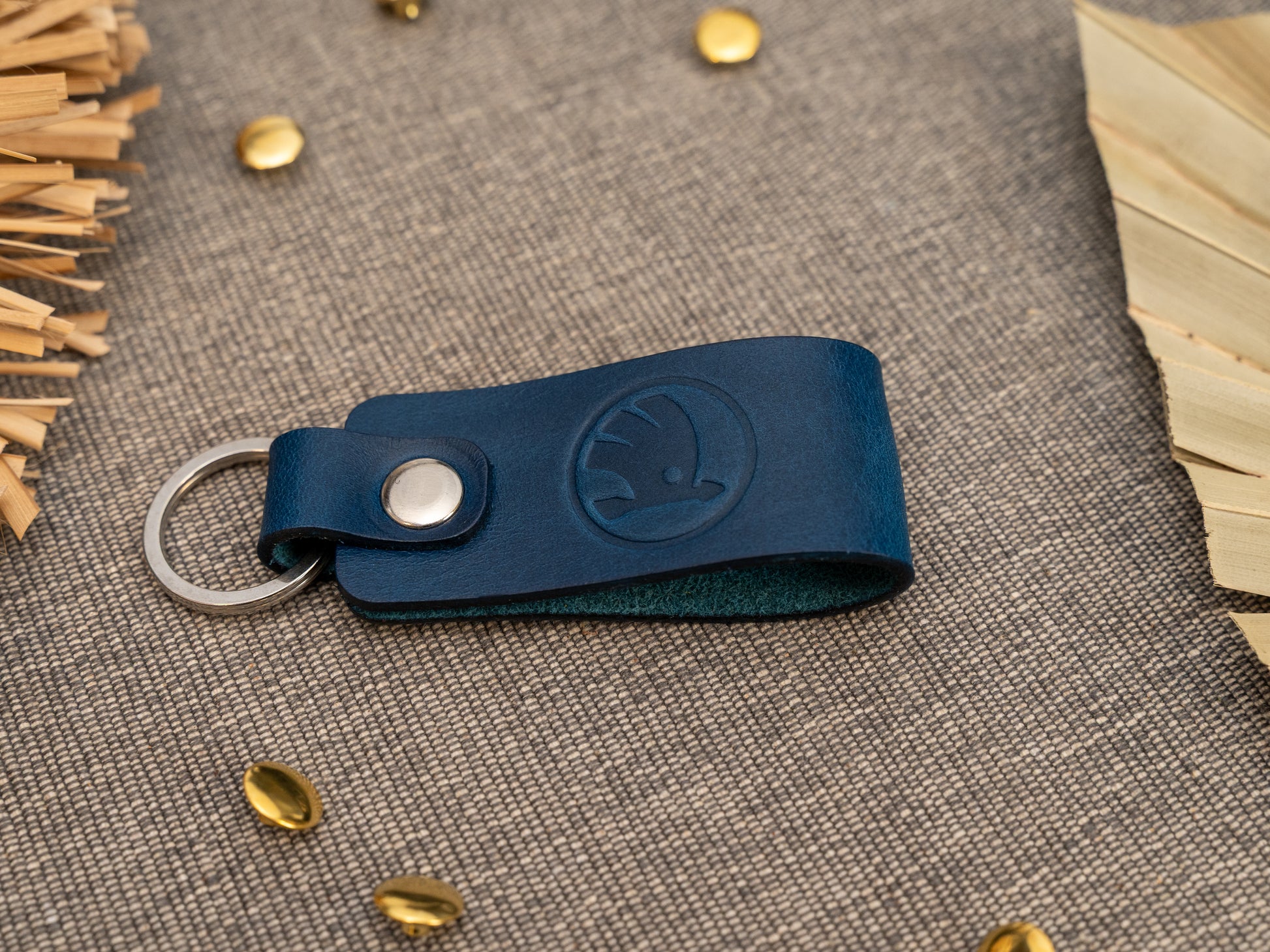 Keyrings with a folded design in navy blue. The keychain has been embossed with the Skoda car logo. Stainless steel split ring and rivet.