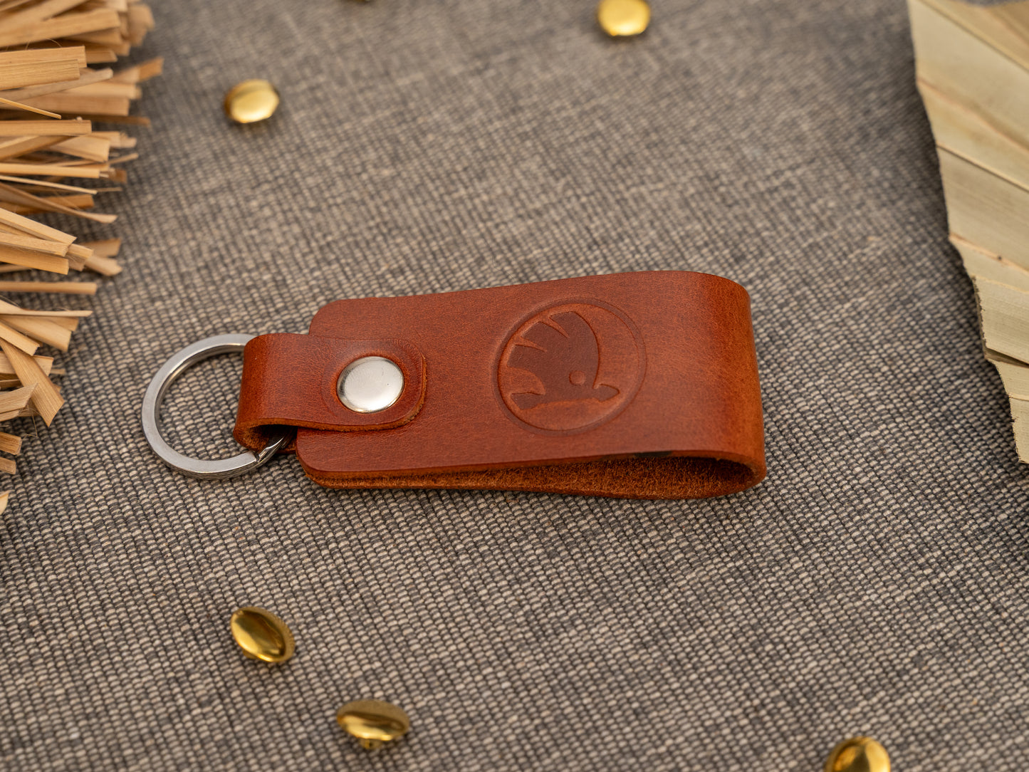 Keyrings with a folded design in tan. The keychain has been embossed with the Skoda car logo. Stainless steel split ring and rivet.