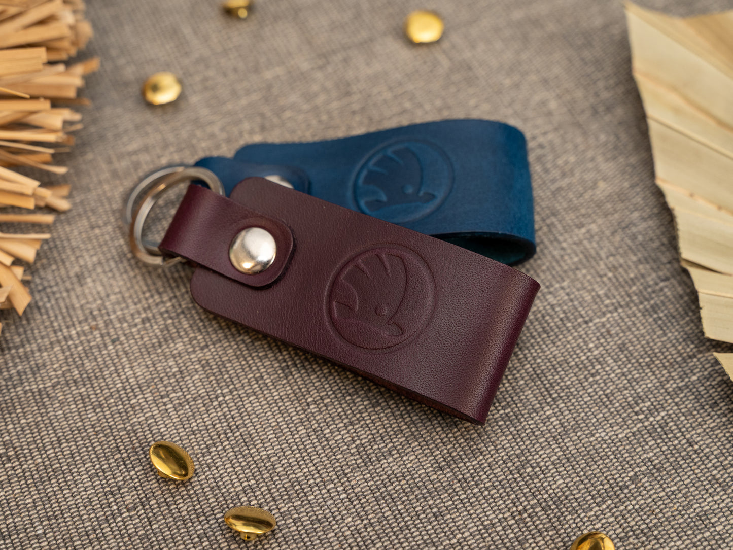 Keyrings with a folded design in purple and navy blue. The keychain has been embossed with the Skoda car logo. Stainless steel split ring and rivet.