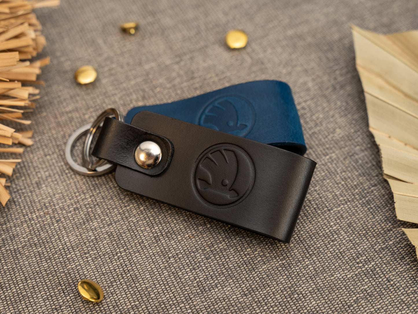Keyrings with a folded design in black and navy blue. The keychain has been embossed with the Skoda car logo. Stainless steel split ring and rivet.