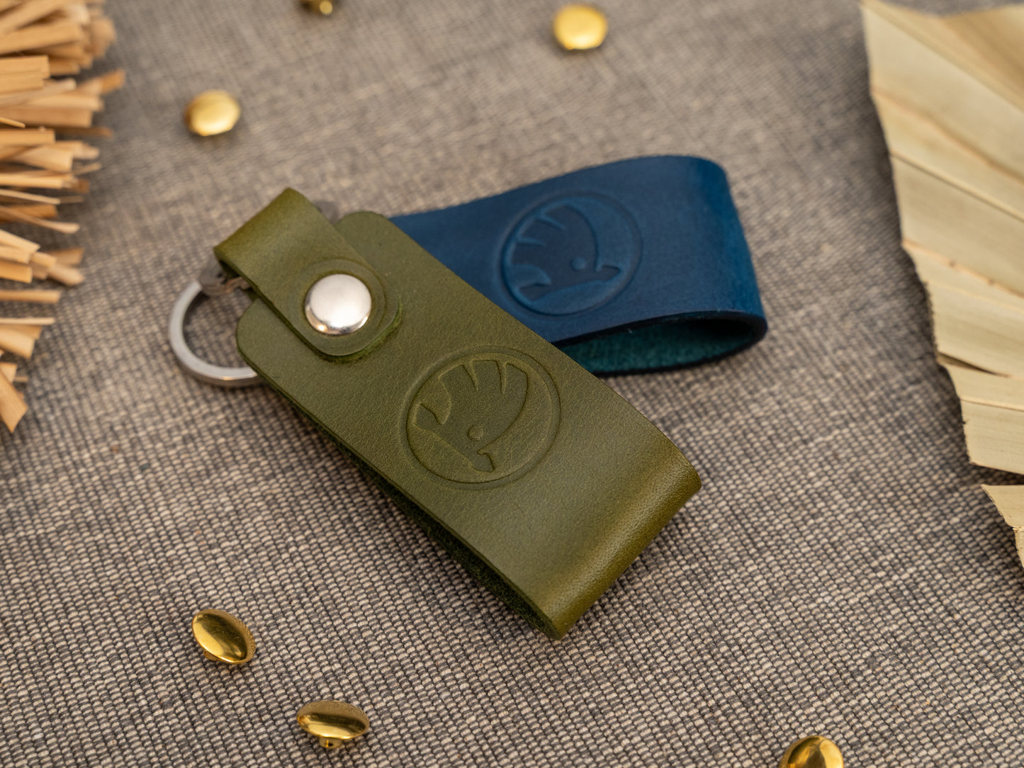 Keyrings with a folded design in olive green and navy blue. The keychain has been embossed with the Skoda car logo. Stainless steel split ring and rivet.