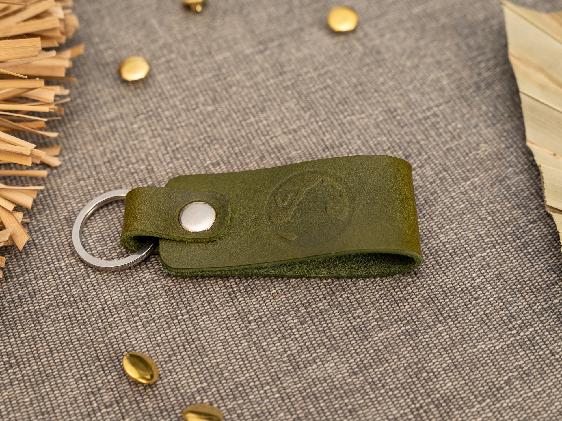Folded olive green leather keyring/keychain with the Vauxhall car logo debossed on it. Made from full grain leather with stainless steel split ring and rivet.