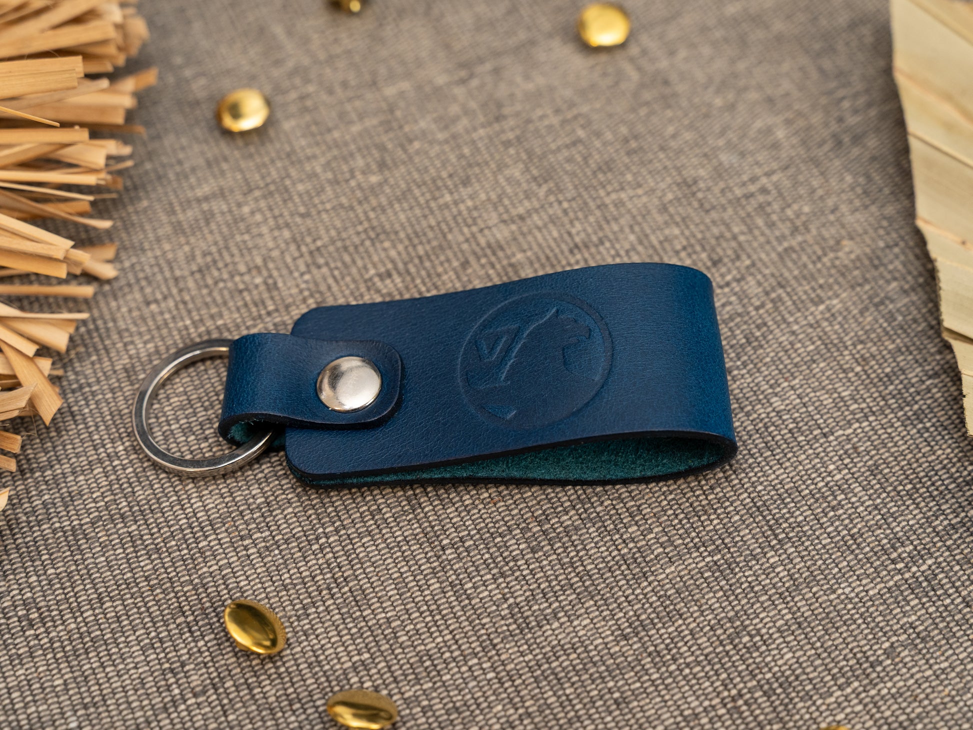 Folded navy blue leather keyring/keychain with the Vauxhall car logo debossed on it. Made from full grain leather with stainless steel split ring and rivet.