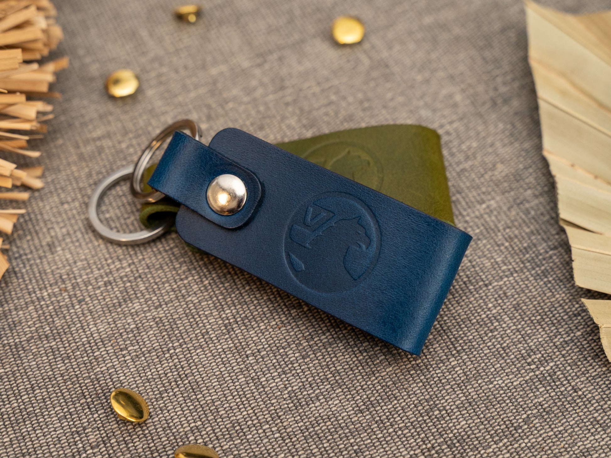 Folded navy blue and olive green leather keyrings/keychains with the Vauxhall car logo debossed on them. Made from full grain leather with stainless steel split ring and rivet.