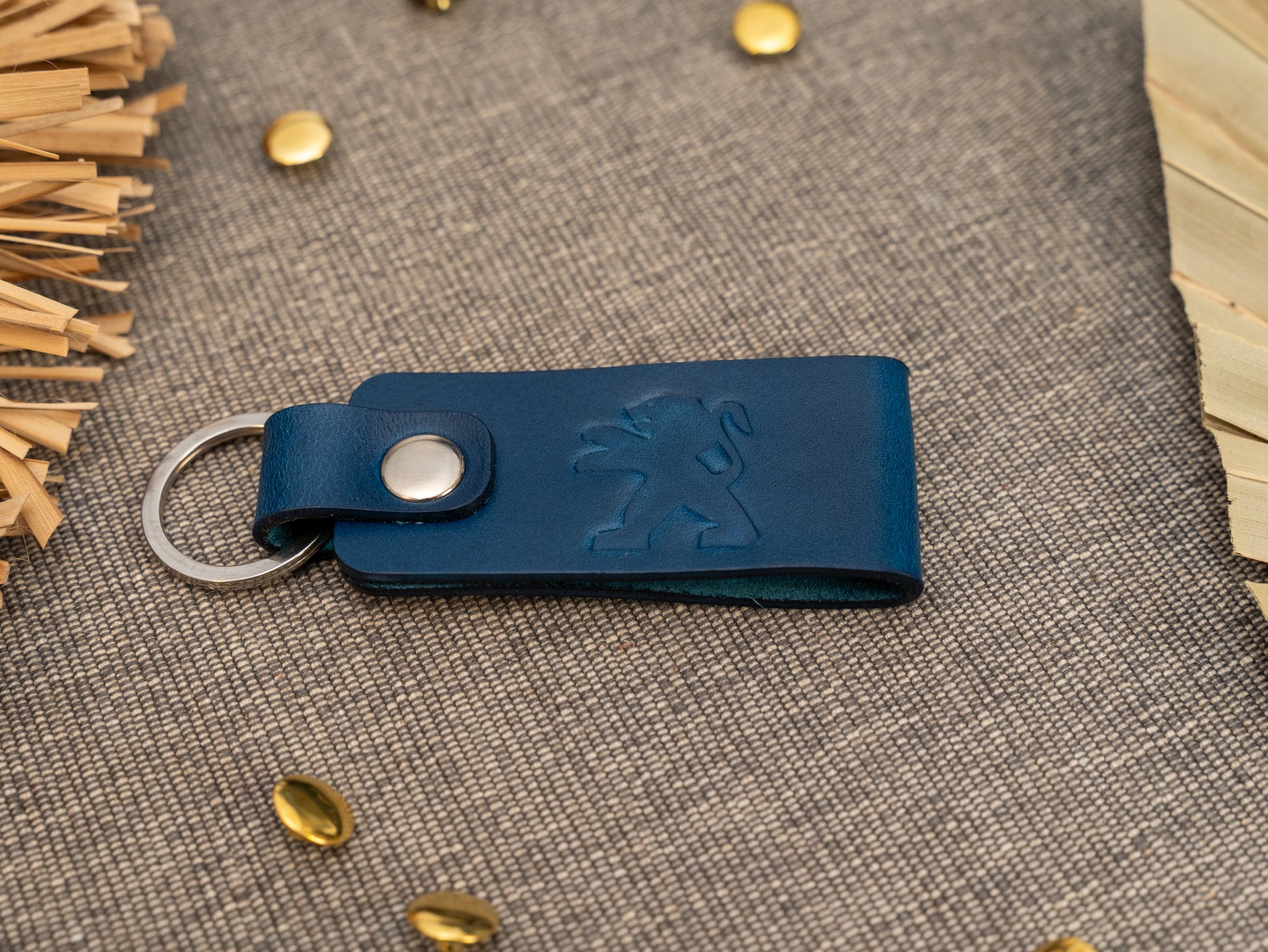 Folded navy blue leather keyring/keychain with the Peugeot car logo debossed on it. Made from full grain leather.