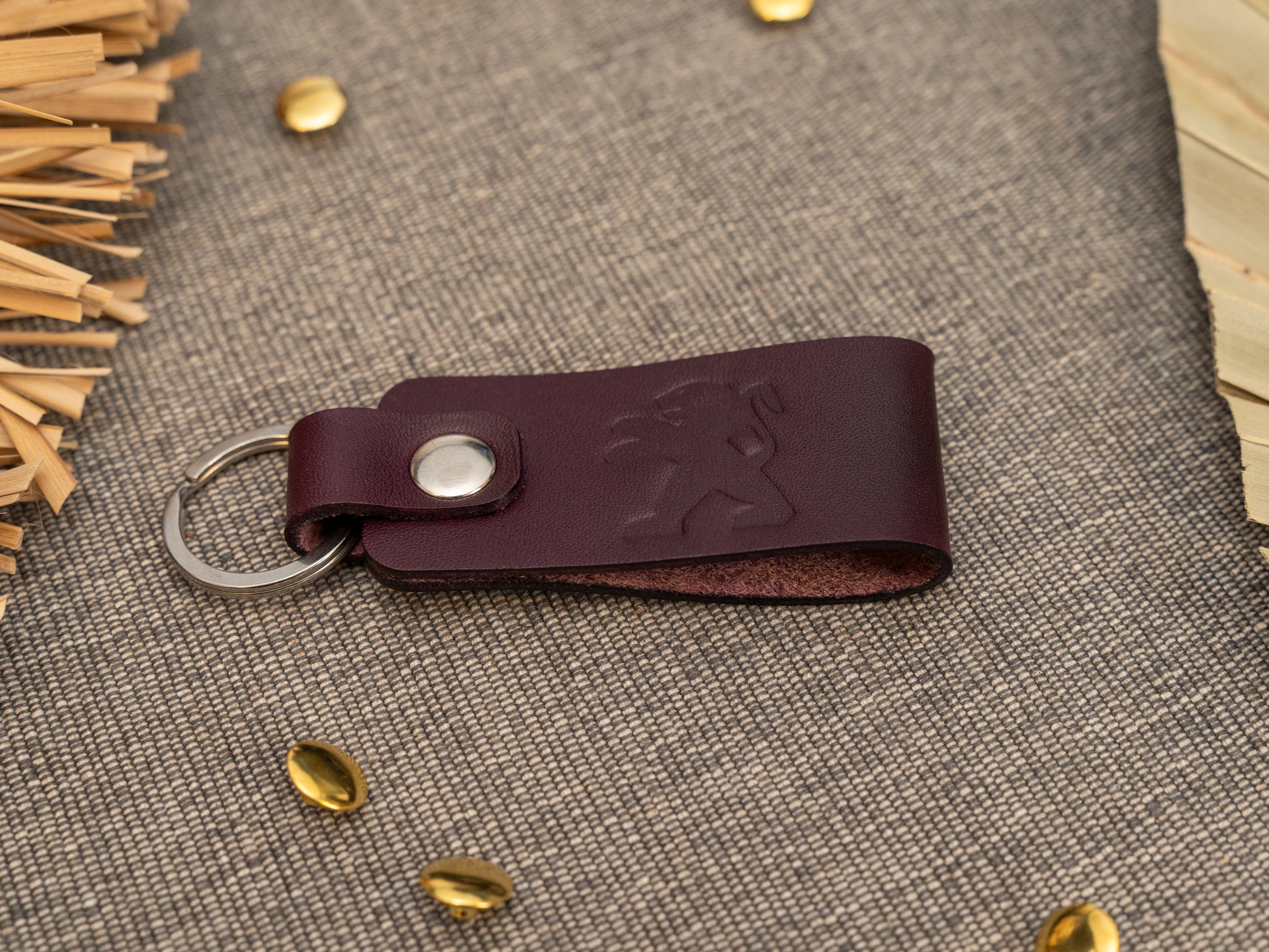 Folded purple leather keyring/keychain with the Peugeot car logo debossed on it. Made from full grain leather.