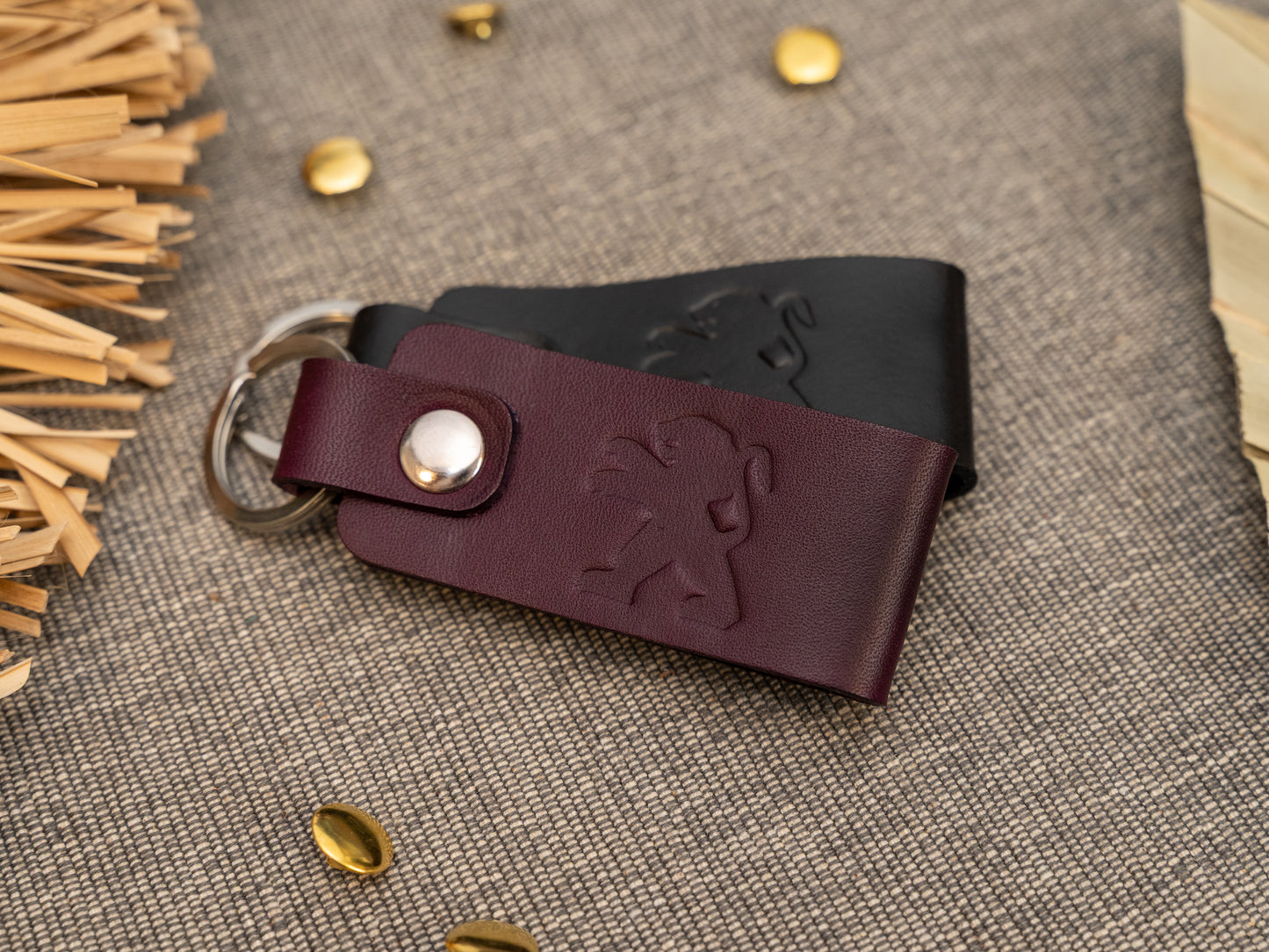 Folded purple and black leather keyrings/keychains with the Peugeot car logo debossed on them. Made from full grain leather.