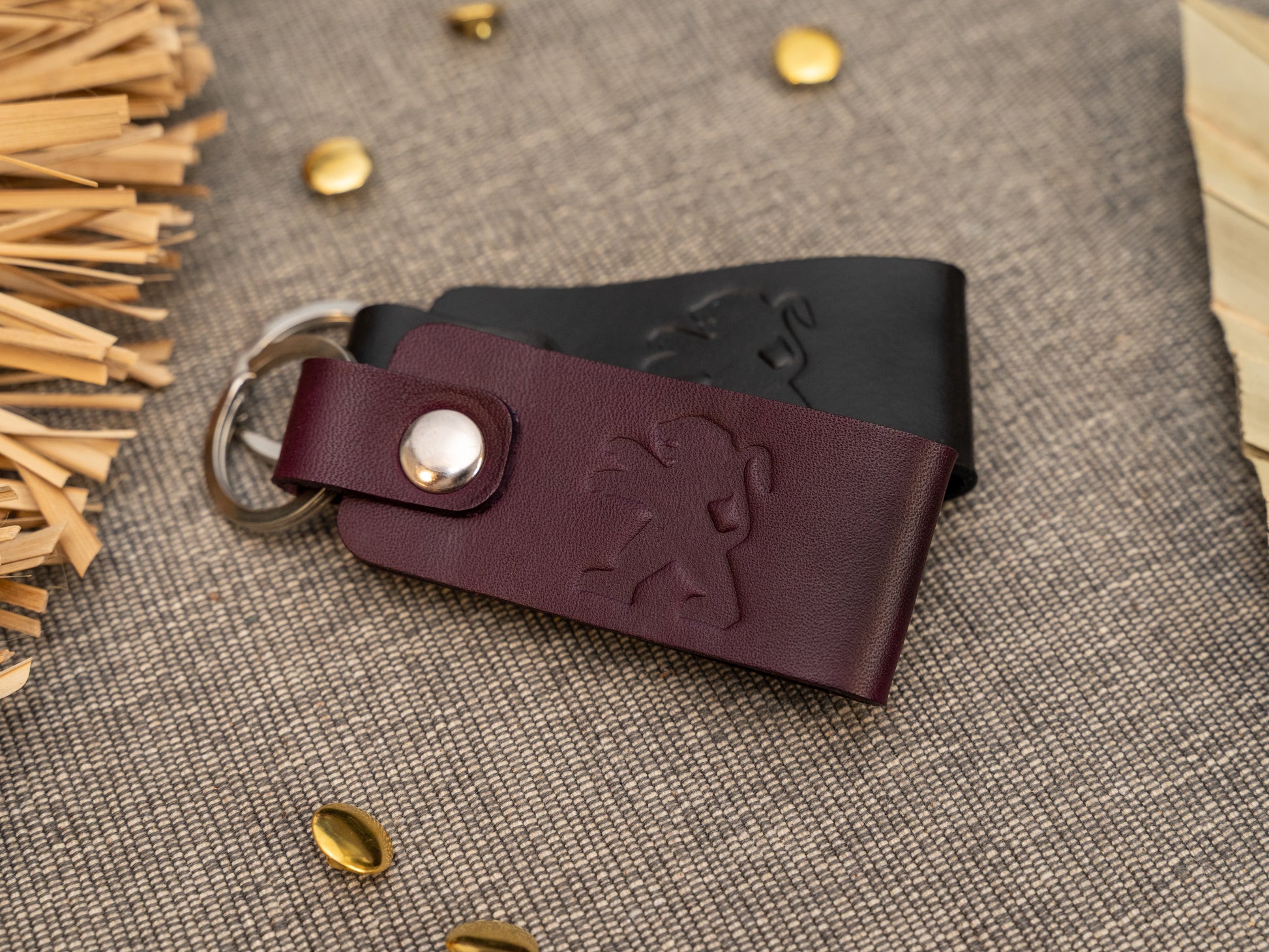 Folded purple and black leather keyrings/keychains with the Peugeot car logo debossed on them. Made from full grain leather.