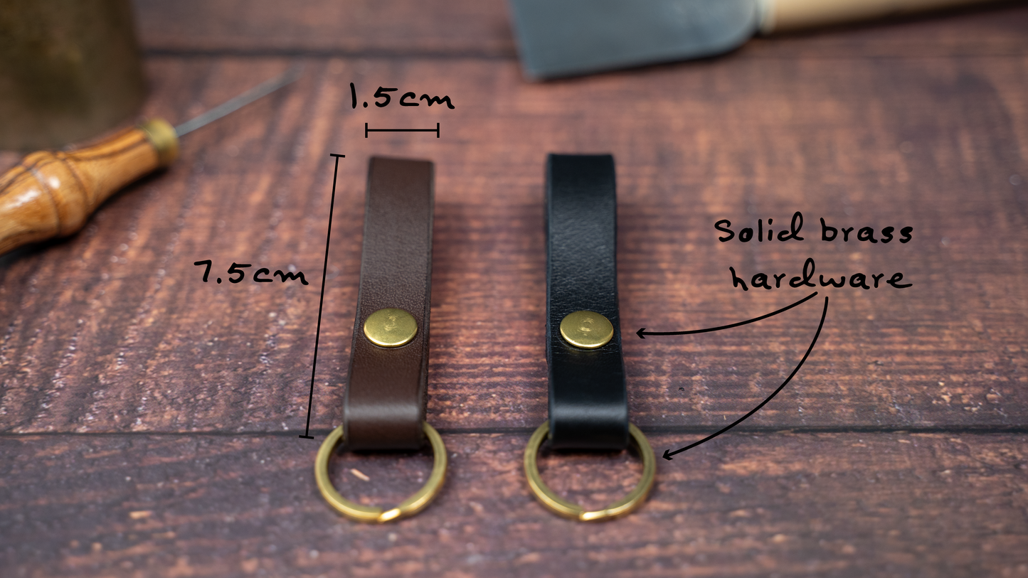 Slim leather loop keyrings/keychains in dark brown and black side by side with solid brass split ring and rivet. Measurements 7.5cm by 1.5cm wide