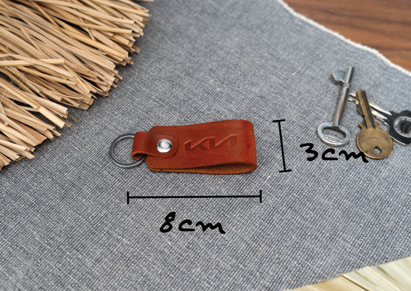 Folded tan leather keyring with the Kia car logo debossed on it. Measuring 8cm by 3cm. Made from Italian full grain leather