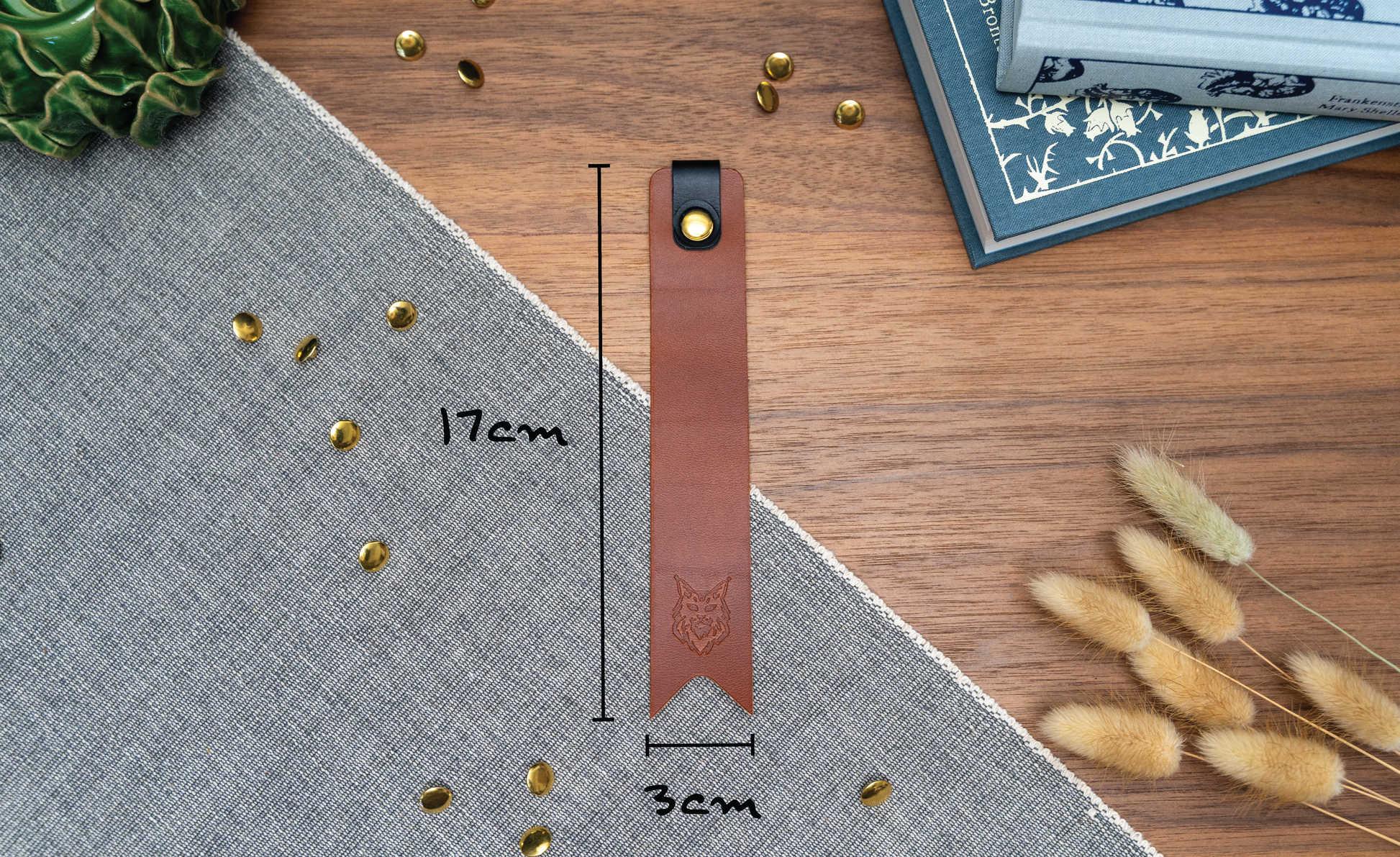 Leather bookmark in tan with a black tab folded over the top and a cut out at the bottom. Bookmark is debossed with an outline of a Maine Coon cats face. Stainless steel and brass rivets used to hold tab in place. Available in red, yellow, tan, olive green, purple, navy blue, dark brown, black with a choice of tab colour. !7cm by 3cm wide.