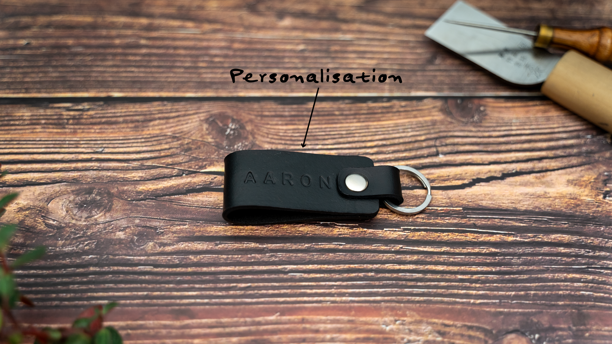 Folded black keyring embossed with name showing personalisation. Stainless steel split ring and rivet.